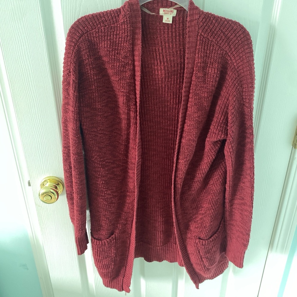 Burgundy and red cardigan. The front of the cardigan has pockets on both sides.
